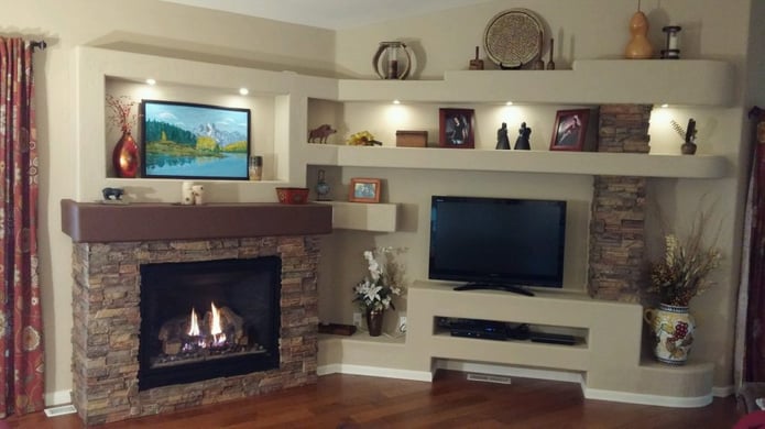 DIY media center and fireplace shelving unit built from scratch and accented with Drystack stone style panels.