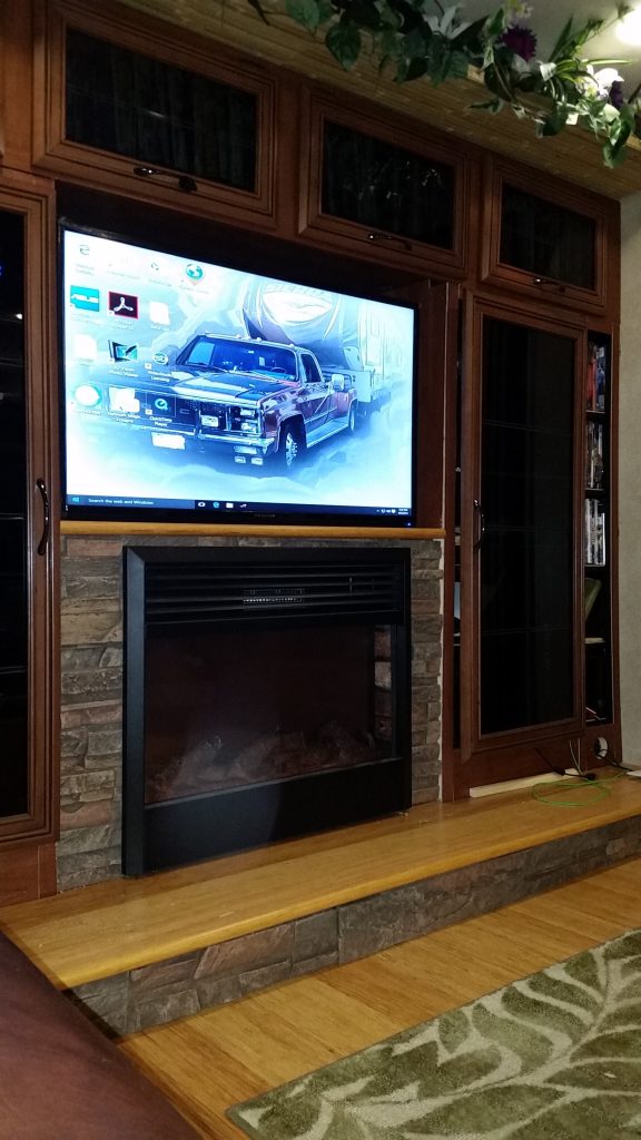 This RV makeover included a new entertainment center and fireplace surrounded by lightweight, stone style panels.