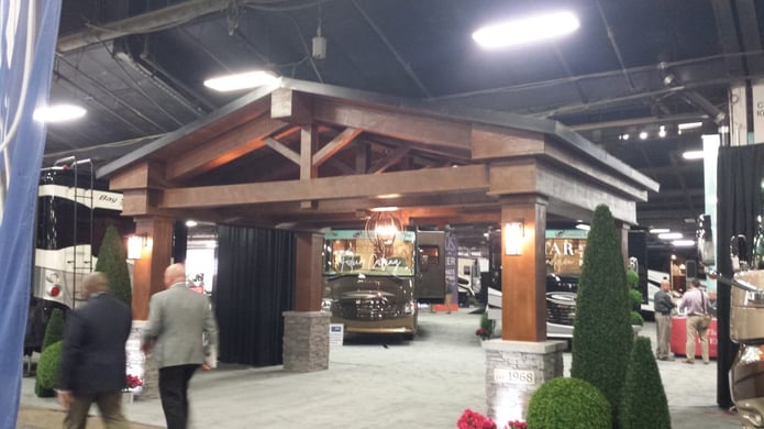 The Newmar Corporation's creative exhibition booth design featured faux stone column wraps at the 4 corners of the display.