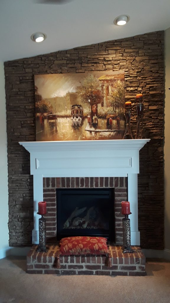 Fireplace backdrop created with stacked stone style panels in Taffy Beige color.