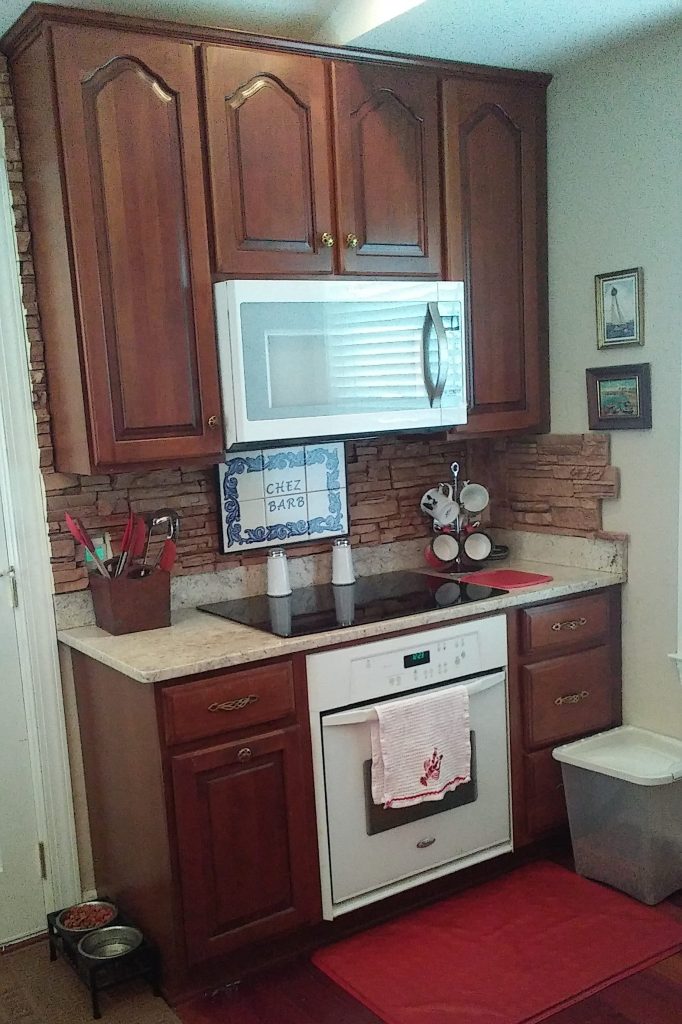 Easy backsplash built with stacked stone style panels installed behind a kitchen stove.