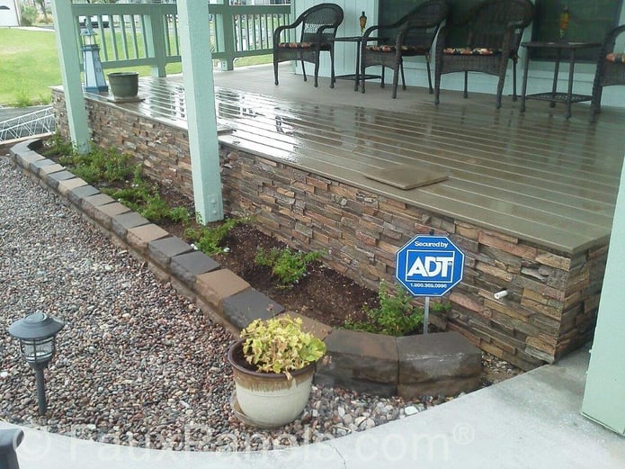 Seamless stone look deck siding created with weatherproof faux panels.