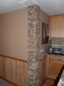 Basement wall corner accented with stacked stone panels.