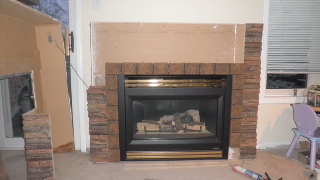Interlocking panels being installed as a fireplace surround.