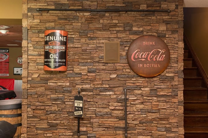 Basement wall with a secret door behind the stone style paneling.