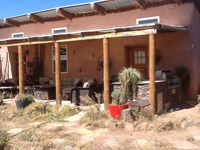 Patio of southwestern style home with new outdoor kitchen including BBQ island with a faux stone finish.
