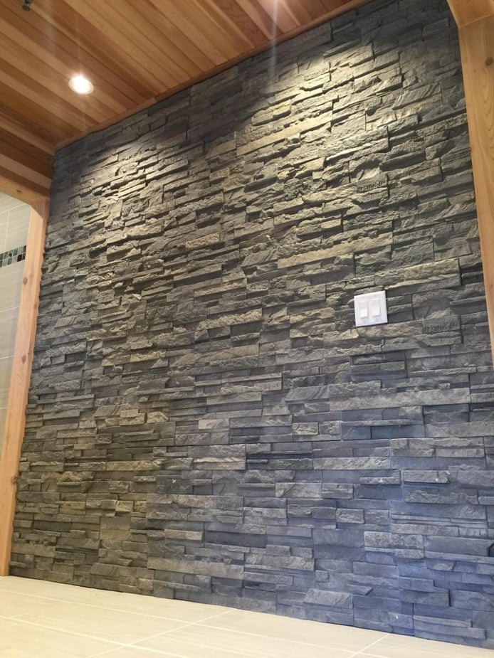 This sauna's design included an accent wall covered with Wellington Dry Stack panels in London Gray color.