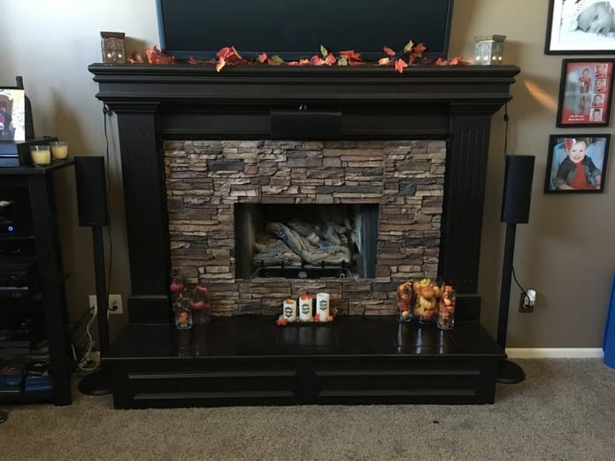 A former tiled fireplace updated with Norwich Stacked Stone panels in Sierra Brown color.