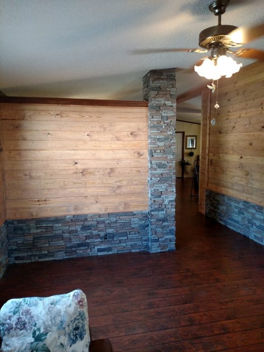 A home's original wainscoting and load bearing columns covered in faux stacked stone.
