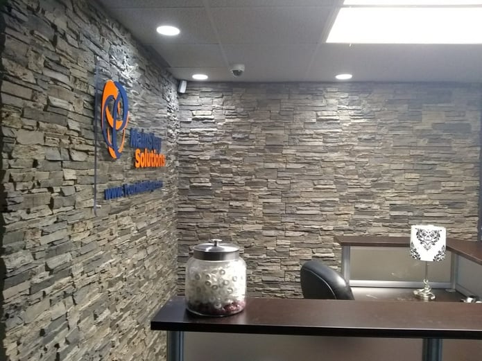 MainStay Solutions office with walls covered in stacked stone panels.