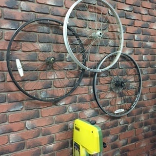 Fixie bike wheels installed as decorative elements to a faux brick accent wall.