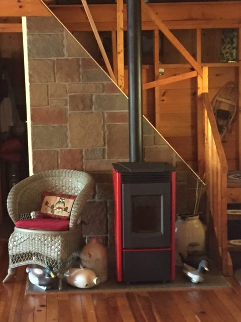 Wood stove surround made from Castle Rock style panels placed on the staircase behind the stove