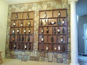 An accent wall of faux fieldstone made for a beautiful addition. Using faux stone panels molded from New England fieldstone, Julie was able to transform the look of her vintage wine shelving to resemble a French wine cellar.