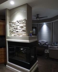 Stacked stone panels were incredibly easy to install. Faux panels start going up on this fireplace remodel.