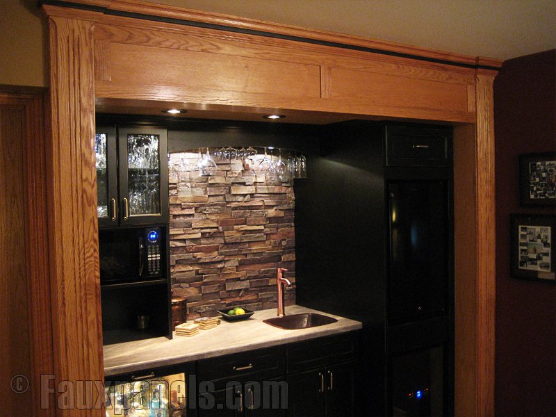 Stone look backsplash installed behind a mini kitchen bar area.