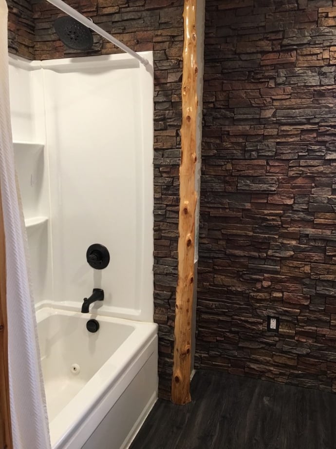 Rustic bathroom remodel with Regency Stacked Stone panels in Earth color on the walls.