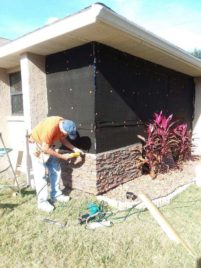 Installing siding on a home with drainage mats.