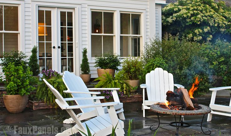 Outdoor living area remodeled with fake stone paneling, Adirondack chairs and a cozy fire pit.