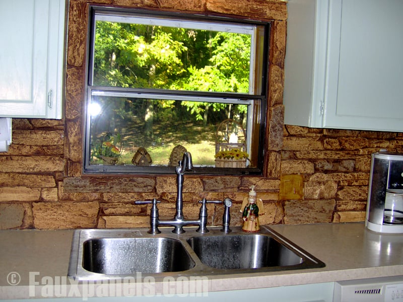 Stone look backsplash behind a kitchen sink.
