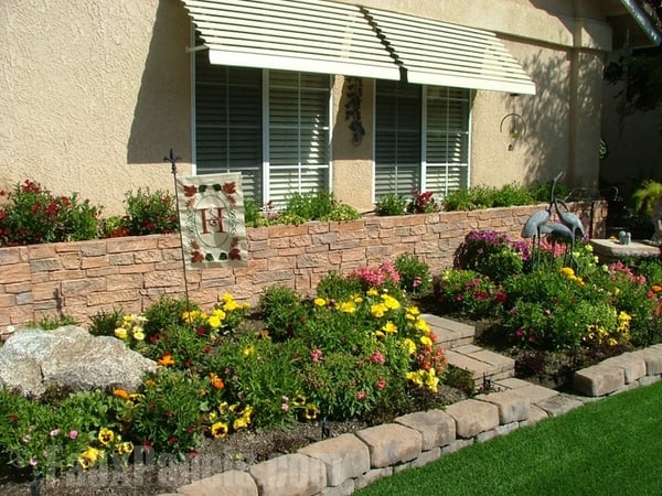 Faux stonewall panels create a beautiful, polished garden retaining wall