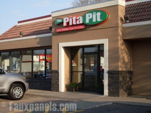 Decorative panels enhance Pita Pit storefront.