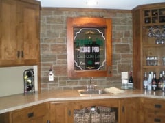 Basement bar backplash created with ledgestone style panels.
