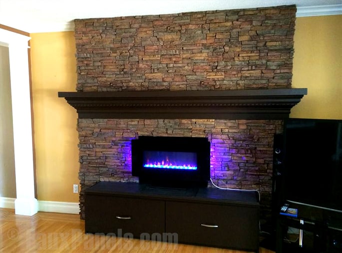 Fireplace veneer with the look of real stacked stone surrounds a home's gas fireplace.