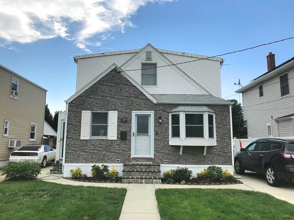 Small home's exterior partially refaced with Norwich Stacked Stone panels in Gray Rock color.